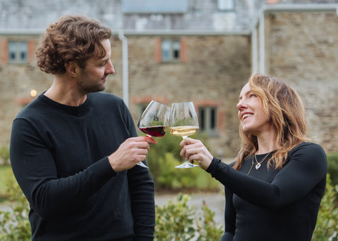 Fiona & Alex holding wine glasses outdoors - cheers!